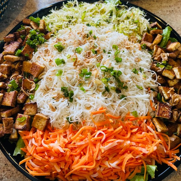 A large platter of Vietnamese vermicelli noodles, shredded cabbage, carrots, and crispy tofu.