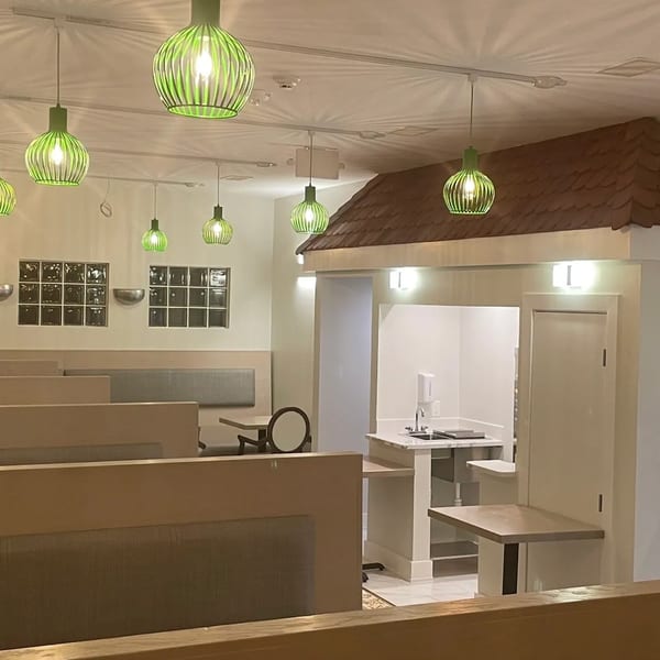 Interior of Saigon Cafe with green pendant lights, booth seating, and a service counter.