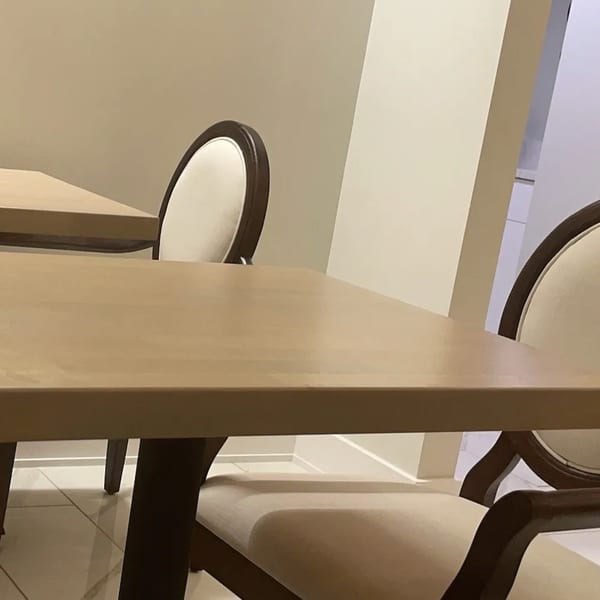 Light wood tables and chairs with dark frames and cream upholstery in Saigon Cafe Millburn.